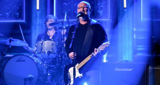 Bob Mould plays The Tonight Show Starring Jimmy Fallon on a stage lit in blue.