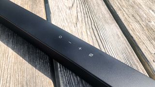 Samsung HW-S800 soundbar showing controls placed on a wooden bench outside