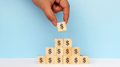 A stack of wooden blocks with dollar signs on them.