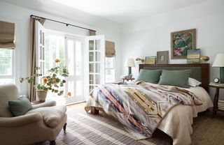 double bed with kelim style throw and French windows open