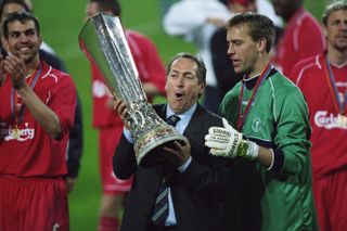 Liverpool manager Gerard Houllier celebrates with the UEFA Cup trophy after the Reds' win over Deportivo Alaves in May 2001.