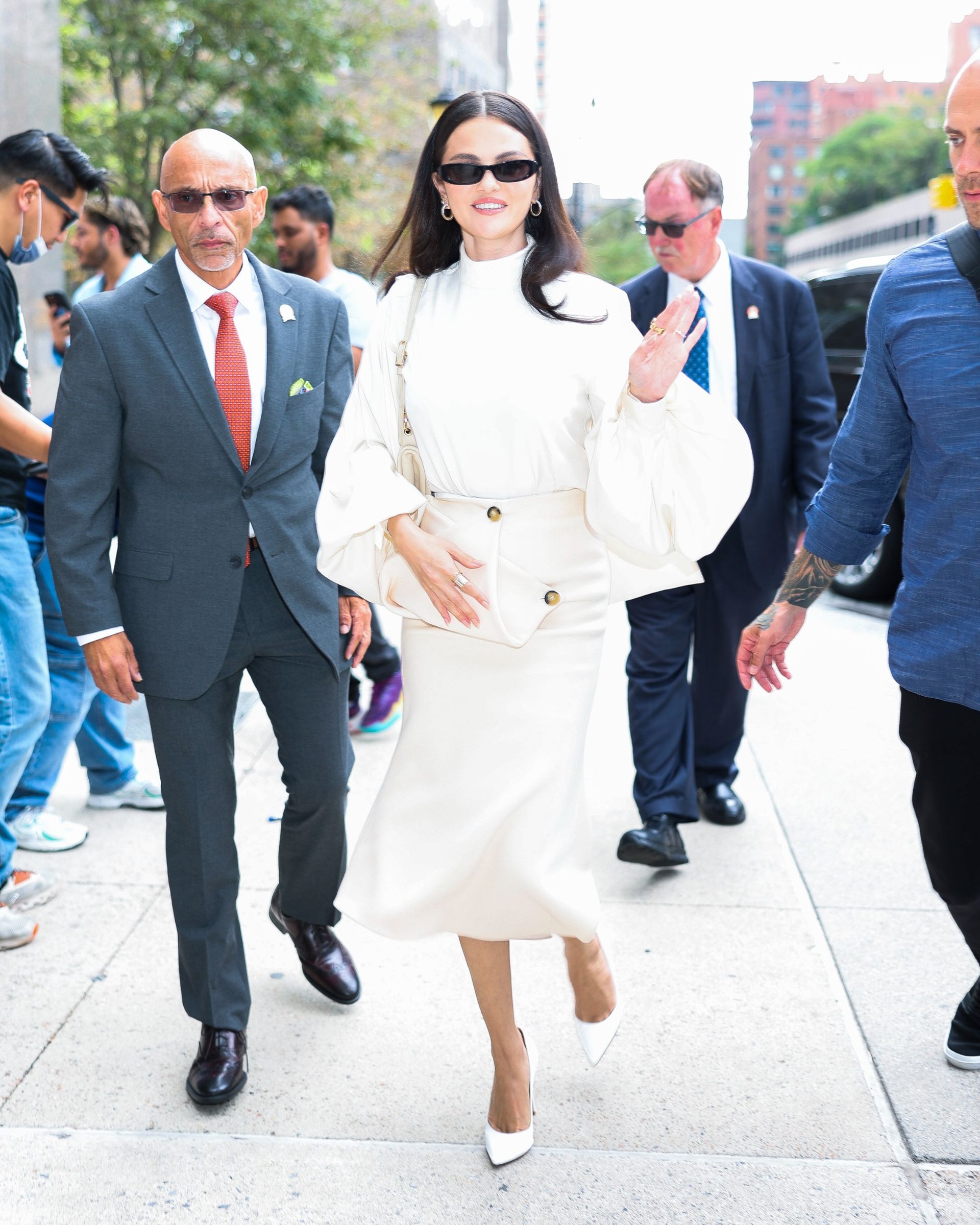 Selena Gomez wears a white turtleneck top with puff sleeves and a matching skirt.