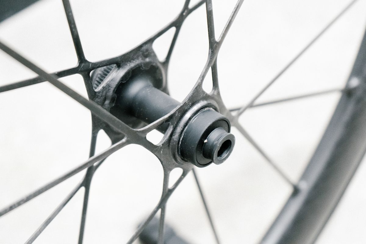 An aero road wheel stands against a white wall