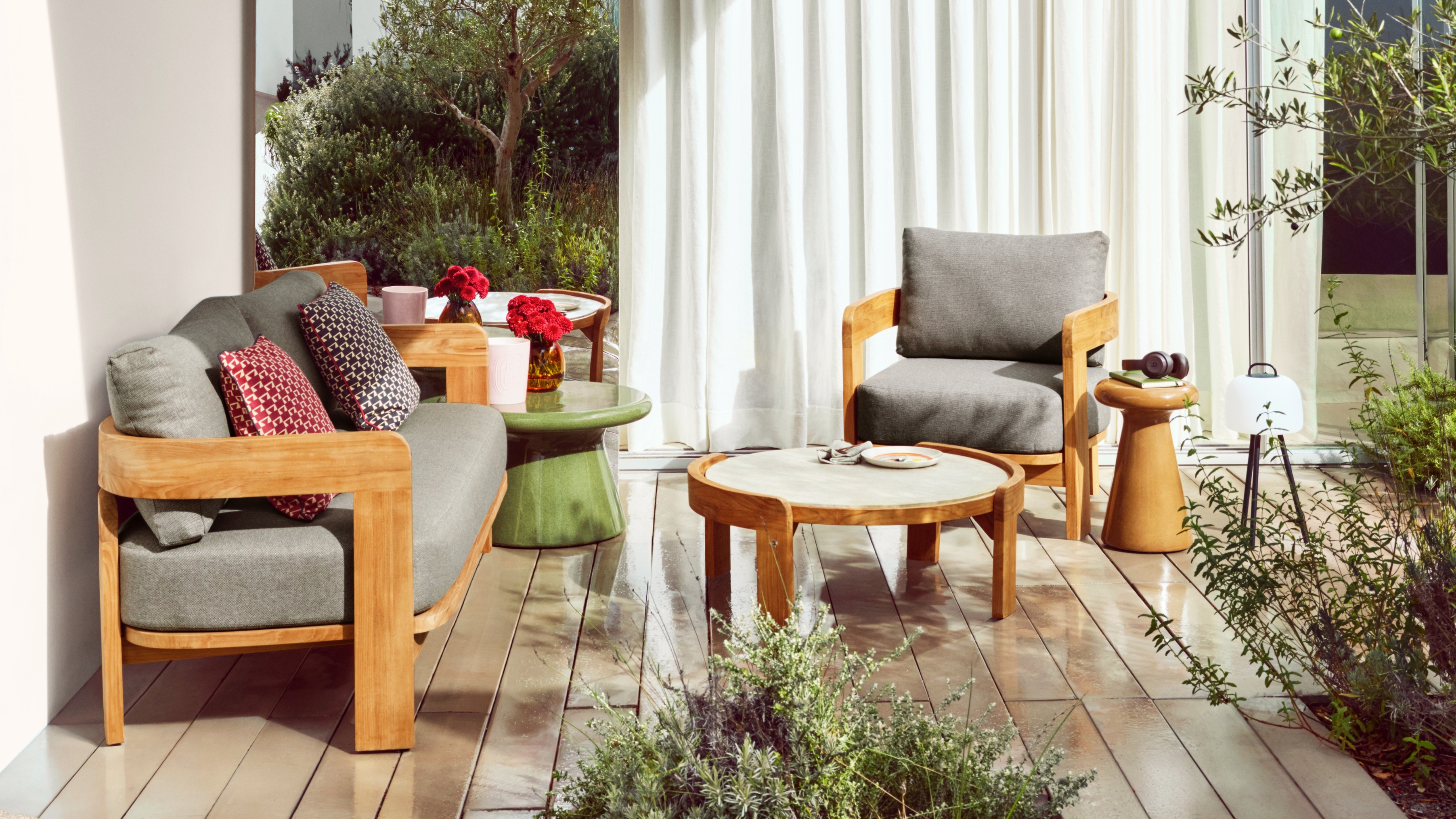 a teak outdoor sofa and chair on a modern patio
