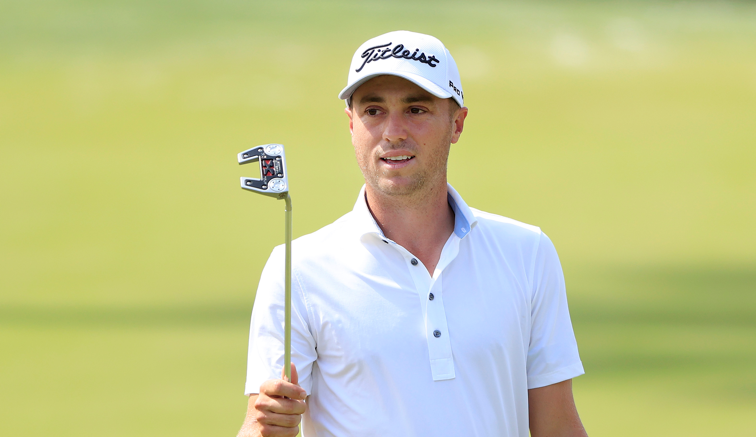 Justin Thomas raises his putter