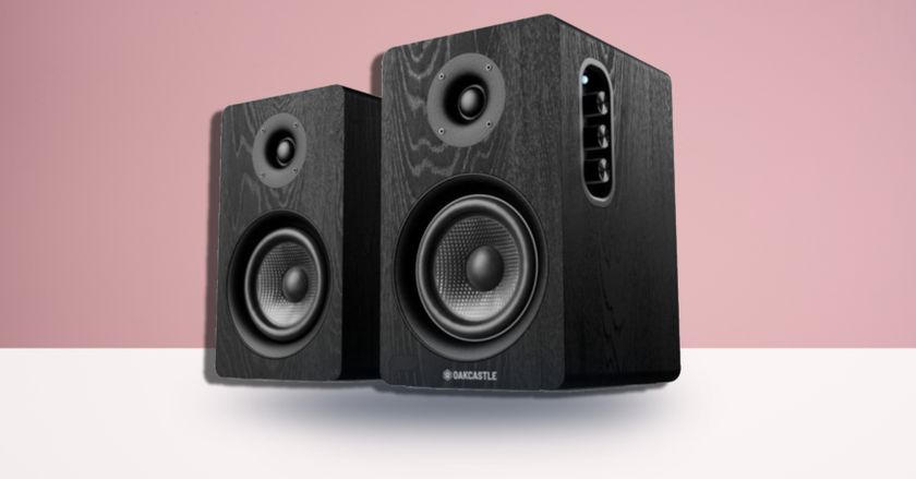 Oakcastle BK100 active bookshelf speakers on pink TR background