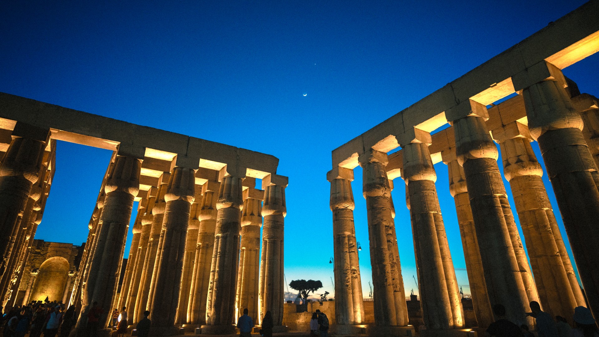 The play of light on the  Luxor Temple's ancient columns, walls, and facades creates a visually stunning scene, emphasizing the temple's imposing presence even in the darkness of the night.