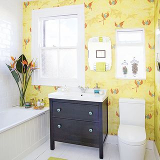 bathroom with yellow wallpaper and white commode