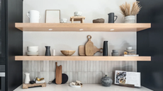 Open pine shelving in modern kitchen space with accessories and tableware