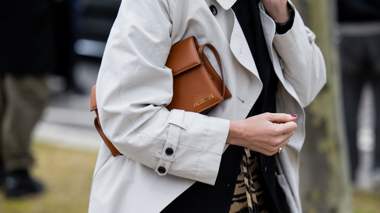 A guest wears grey coat, brown Jacquemus bag, skirt with animal print outside Balenciaga during the Womenswear Fall/Winter 2024/2025 as part of Paris Fashion Week on March 03, 2024 in Paris, France.