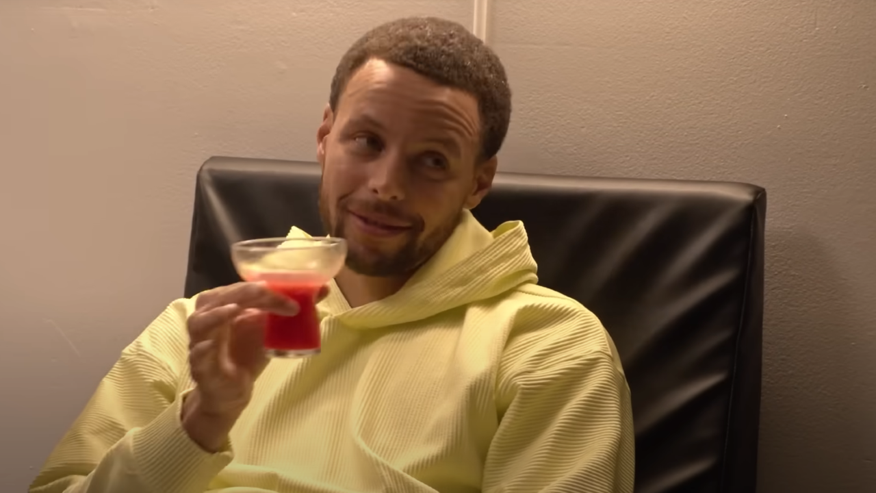 Stephen Curry sosteniendo un cóctel en Mr. Throwback