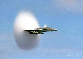 Off the coast of Pusan, South Korea, July 7, 1999, an F/A-18 Hornet breaks the sound barrier.