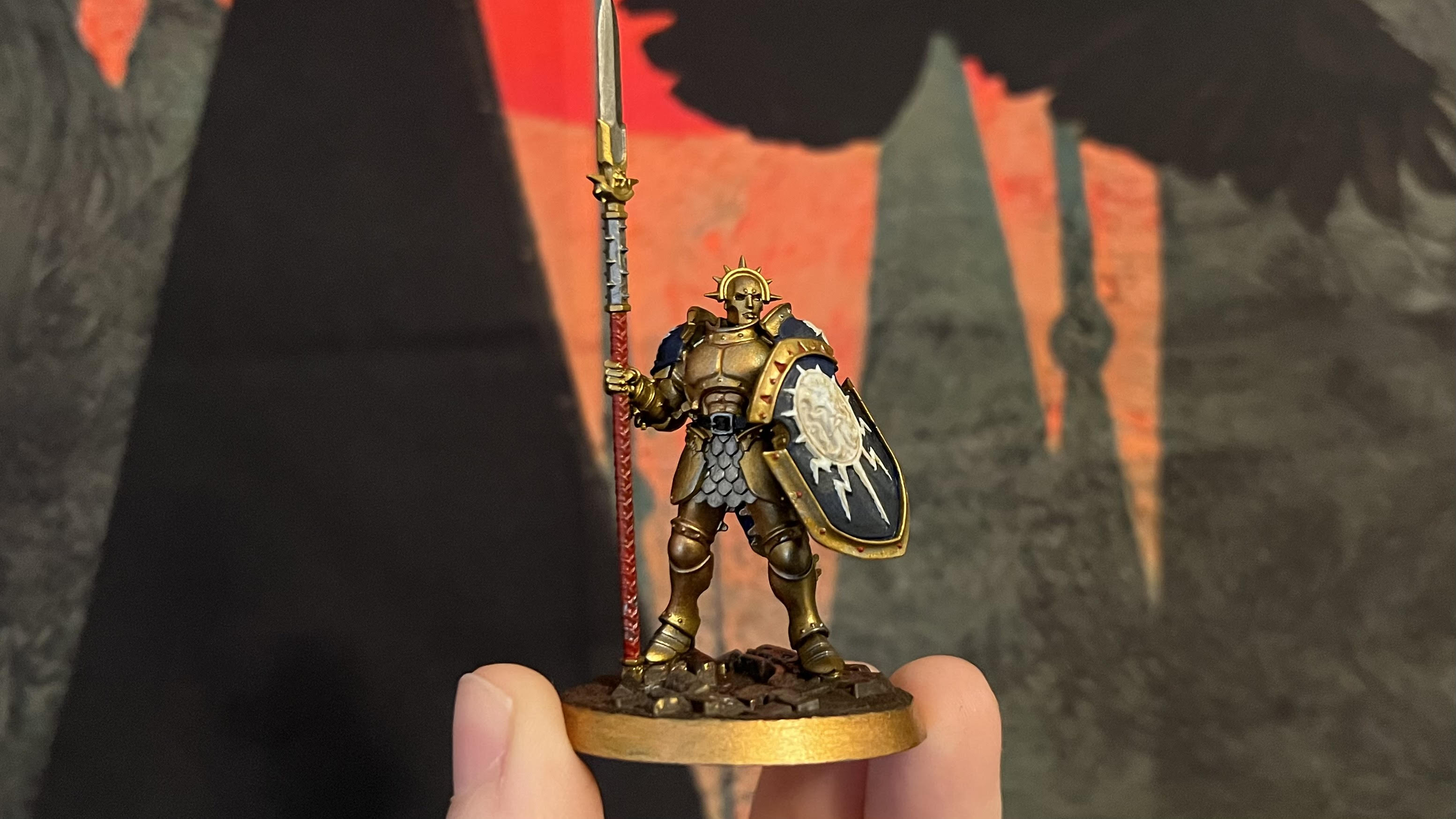 Painted Stormcast Eternal Vindictor mini. It has gold armor and a blue and white shield