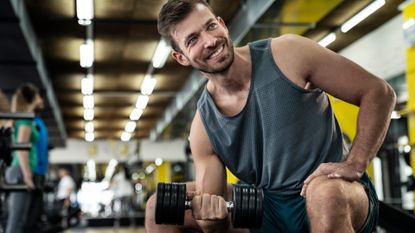 A man doing concentration bicep curls in the gym