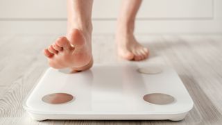 person stepping onto a pair of smart scales