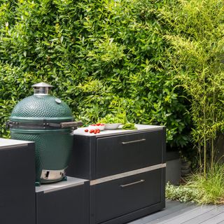 a compact outdoor kitchen with several units and a big green egg BBQ