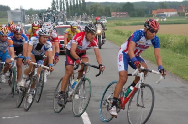 A team US rider leads others around a bend.