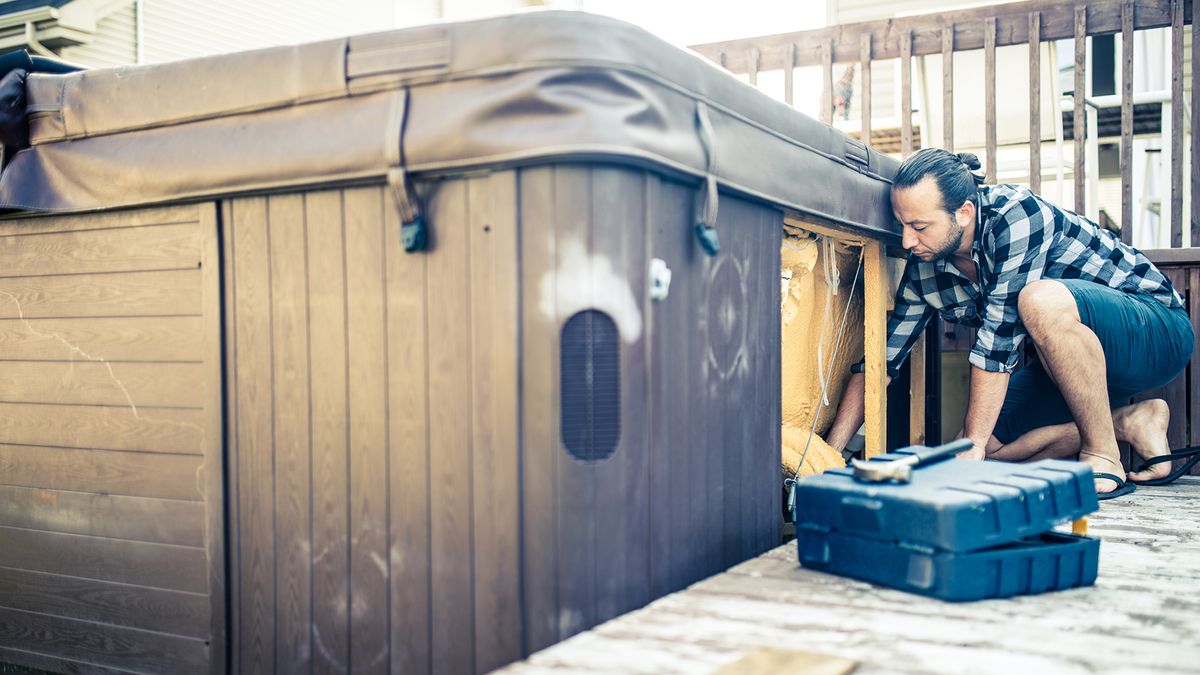 Man installing hot tub on a deck.