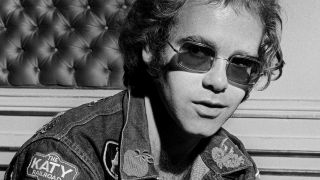 Elton John in 1972 wearing sunglasses and denim jacket