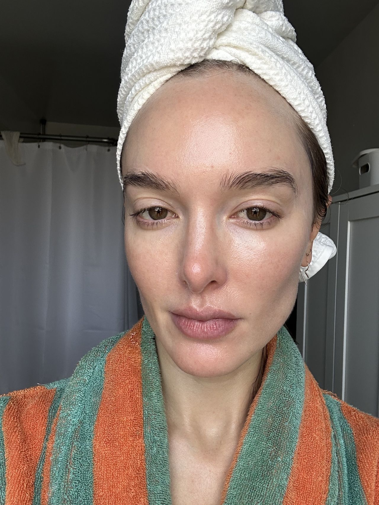 a girl in a green and orange robe and head towel after applying spf.