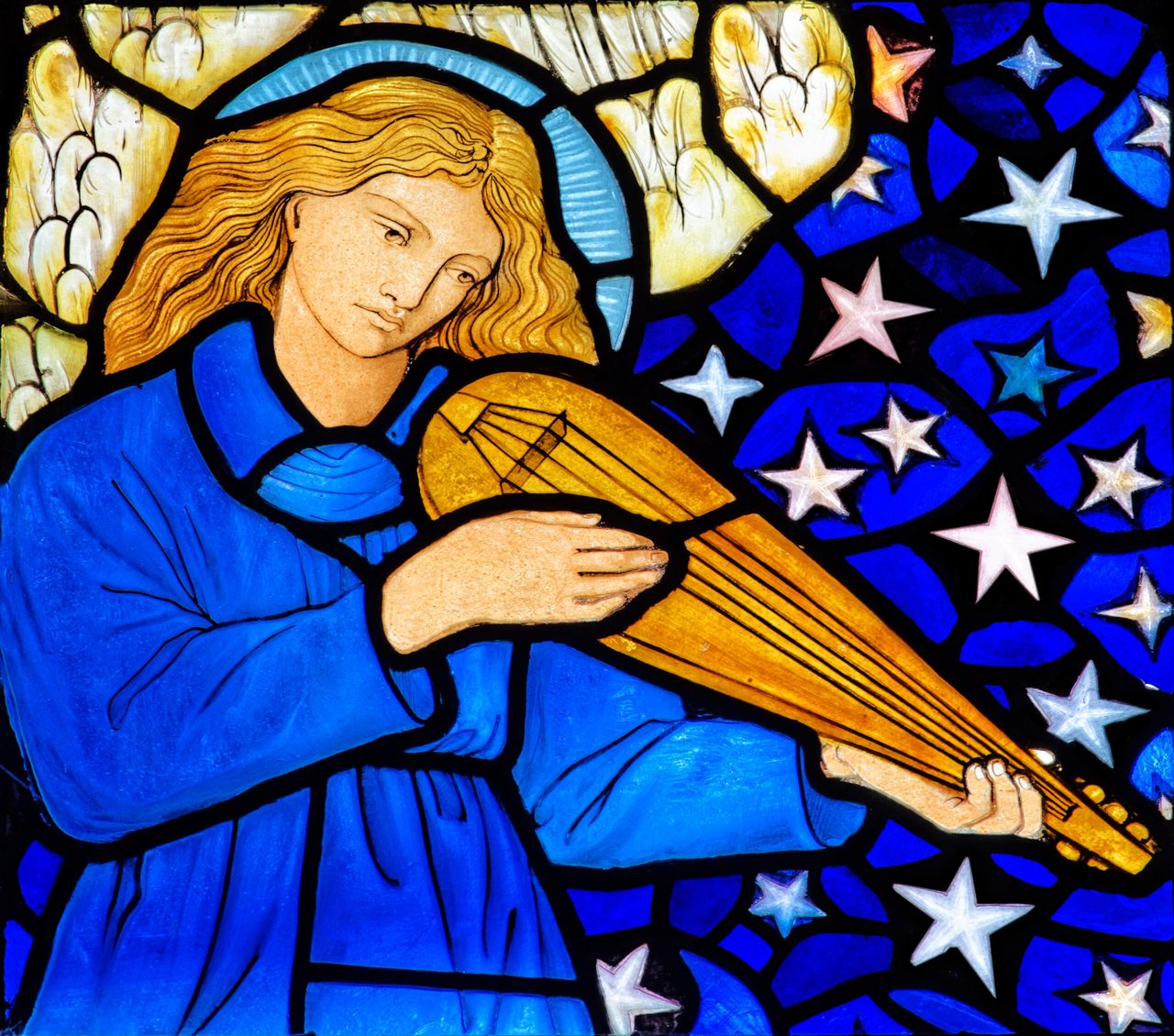 A close-up detail shows one of Edward Burne-Jones&#039;s winged angels playing a mandolin at St James&#039;s, Staveley.