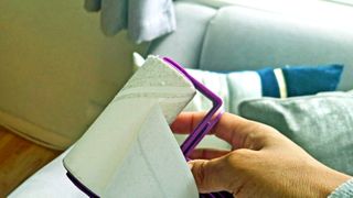 A lint roller being used to clean furniture