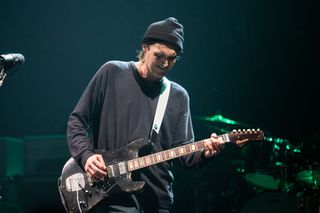 A picture of Josh Klinghoffer playing a guitar on stage