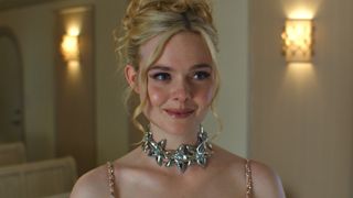 Elle Fanning smiling with up do and a chunky silver necklace in Margo's Got Money Troubles episode "Flamingos"