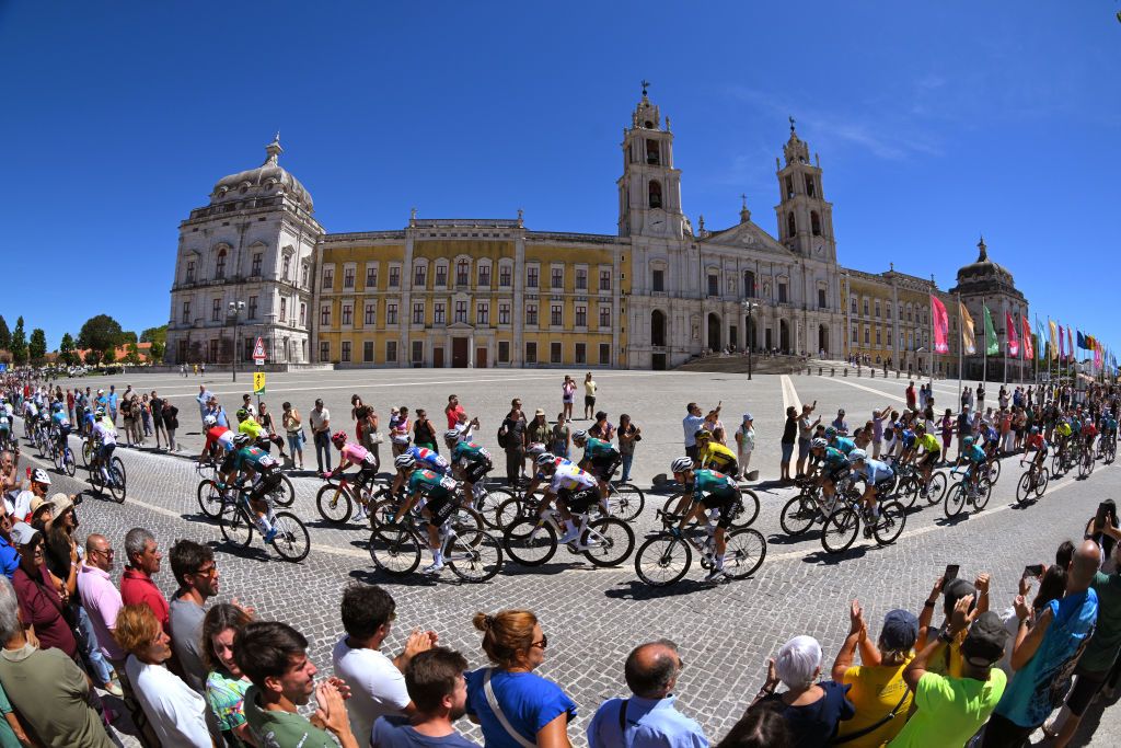 OUREM PORTUGAL AUGUST 18 Jhonatan Narvaez of Ecuador and Team INEOS Grenadiers Unai Iribar of Spain and Team Equipo Kern Pharma Pelayo Sanchez of Spain and Team Movistar and a general view of the peloton passing the Mafra National Palace while fans cheer during the 79th La Vuelta Ciclista a Espana 2024 Stage 2 a 194km stage from Cascais to Ourem UCIWT on August 18 2024 in Ourem Portugal Photo by Tim de WaeleGetty Images