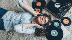 Woman wearing headphones listening to vinyl records