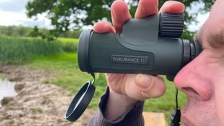 Hawk Endurance ED 10x42 in the hands of the author, demonstrating the top-mounted focus wheel.