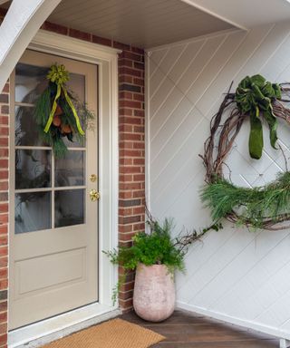 Front porch decorated with wreath and foliage