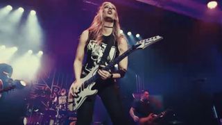 Nita Strauss performs onstage in the music video for her new single, Summer Storm