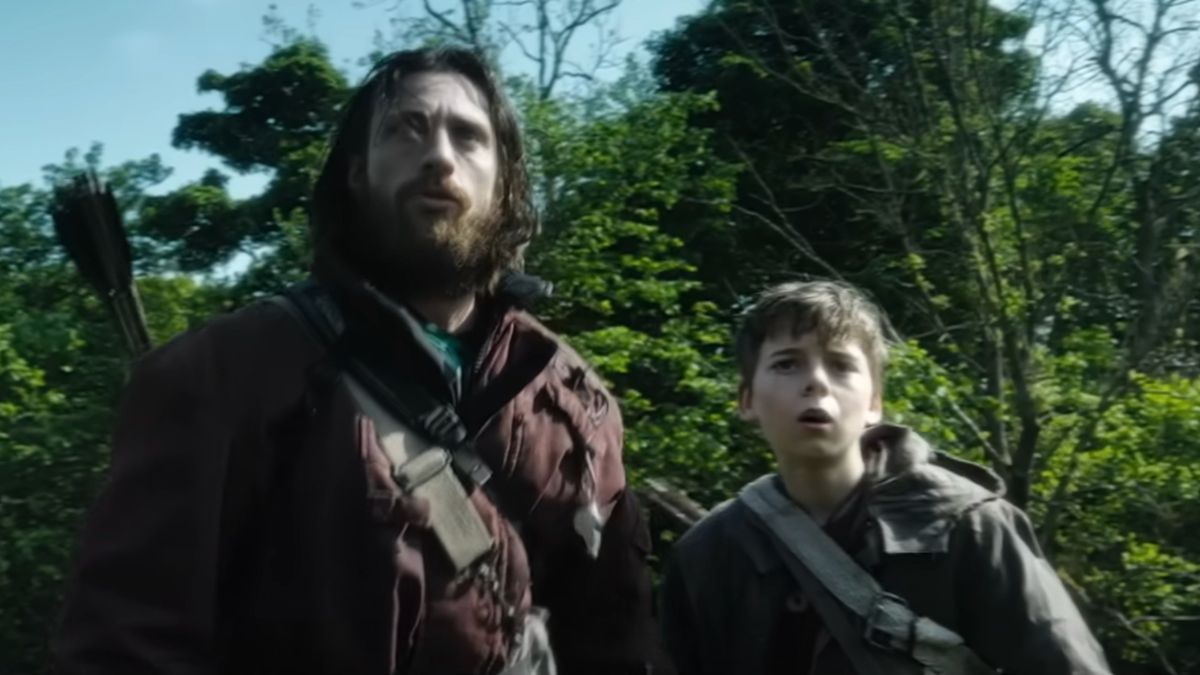 Aaron Taylor-Johnson and Alfie Williams stand frightened in the woods in 28 Years Later.