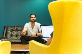 Man facing an interviewer in a yellow chair