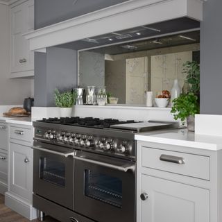 A modern kitchen with mirrored splashback and range cooker
