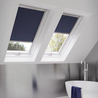 Sloped ceiling bathroom with velux windows and navy blackout blinds