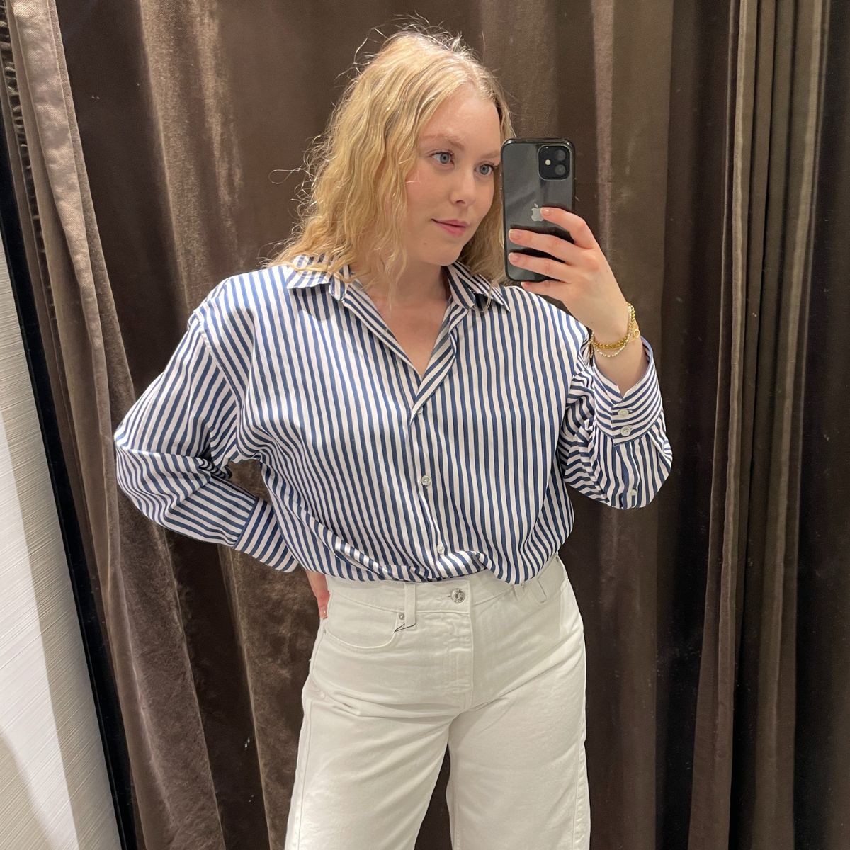 Woman wears blue white striped shirt and white jeans