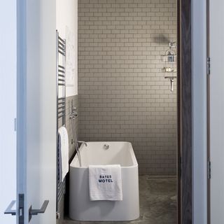 bathroom with exposed brick walls and white bathtub