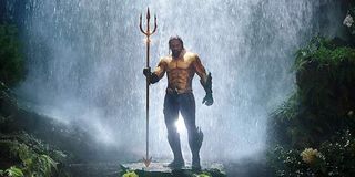 Jason Momoa in his Aquaman costume by a waterfall