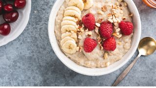 Quinoa porridge with bananas and raspberries with nuts in bowl