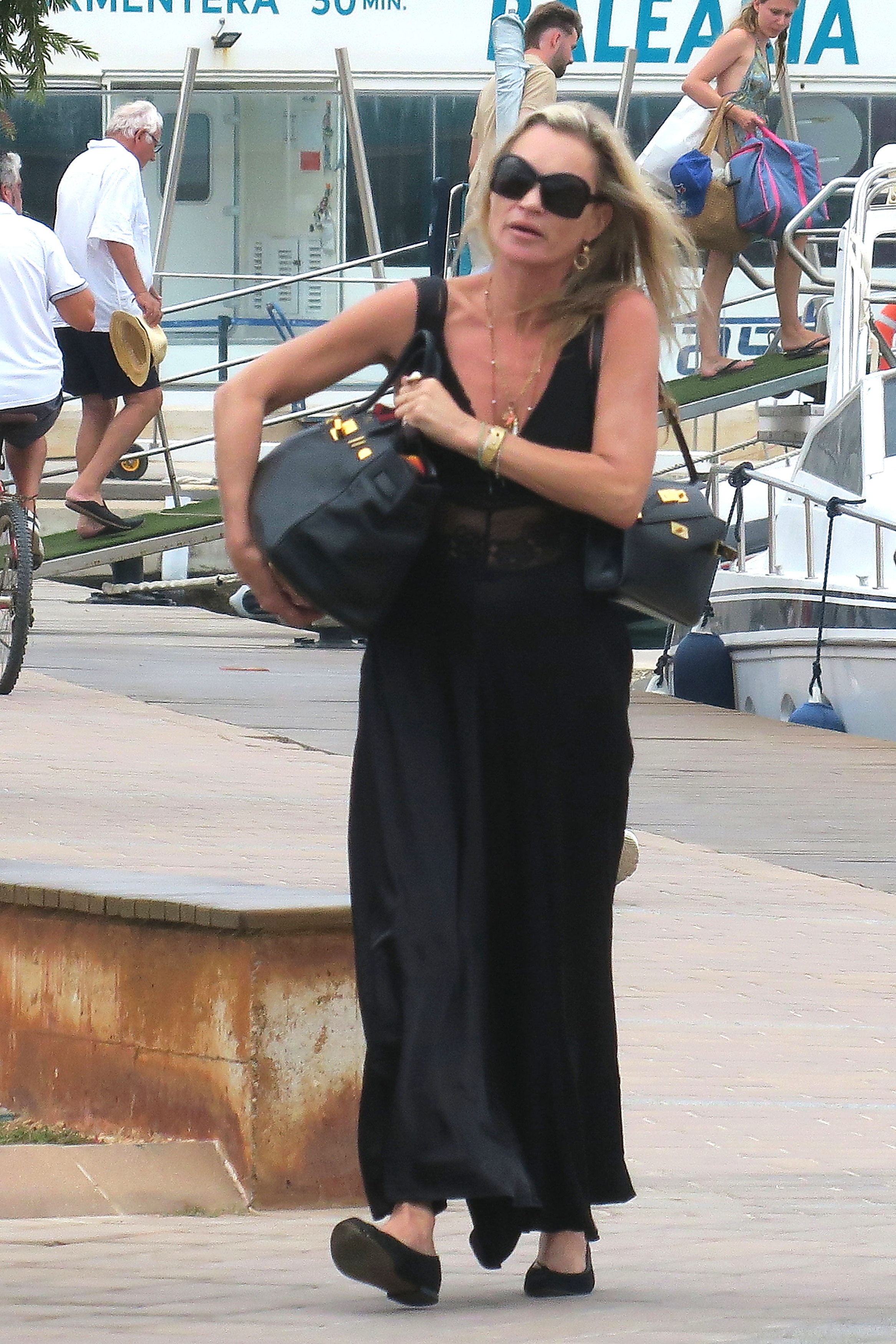 An image of Kate Moss wearing an Herm&egrave;s Birkin and Herm&egrave;s Kelly with ballet flats whilst in Formentera.