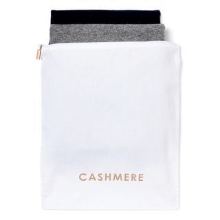 A cutout of a special cashmere pouch with two jumpers poking out