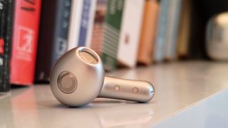 The Xiaomi Buds 5 on a bookshelf.