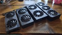 Four budget graphics cards lined up in a row on a wooden desk