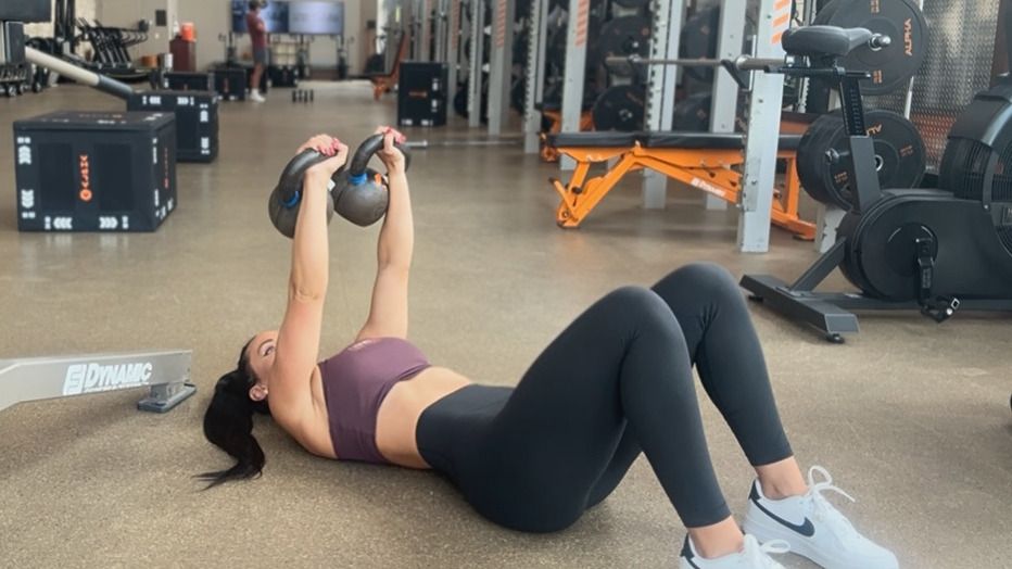 Woman exercising with kettlebells in gym