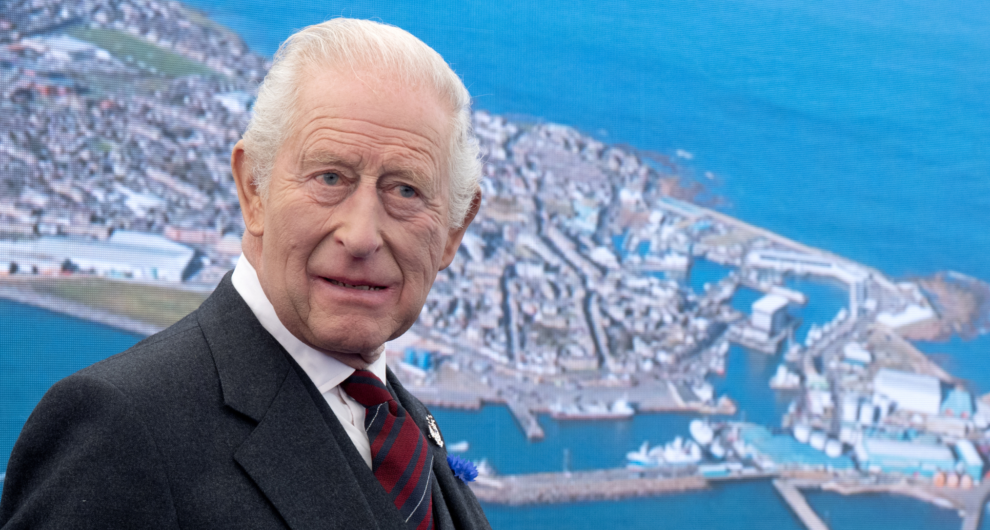 King Charles standing in front of a map 