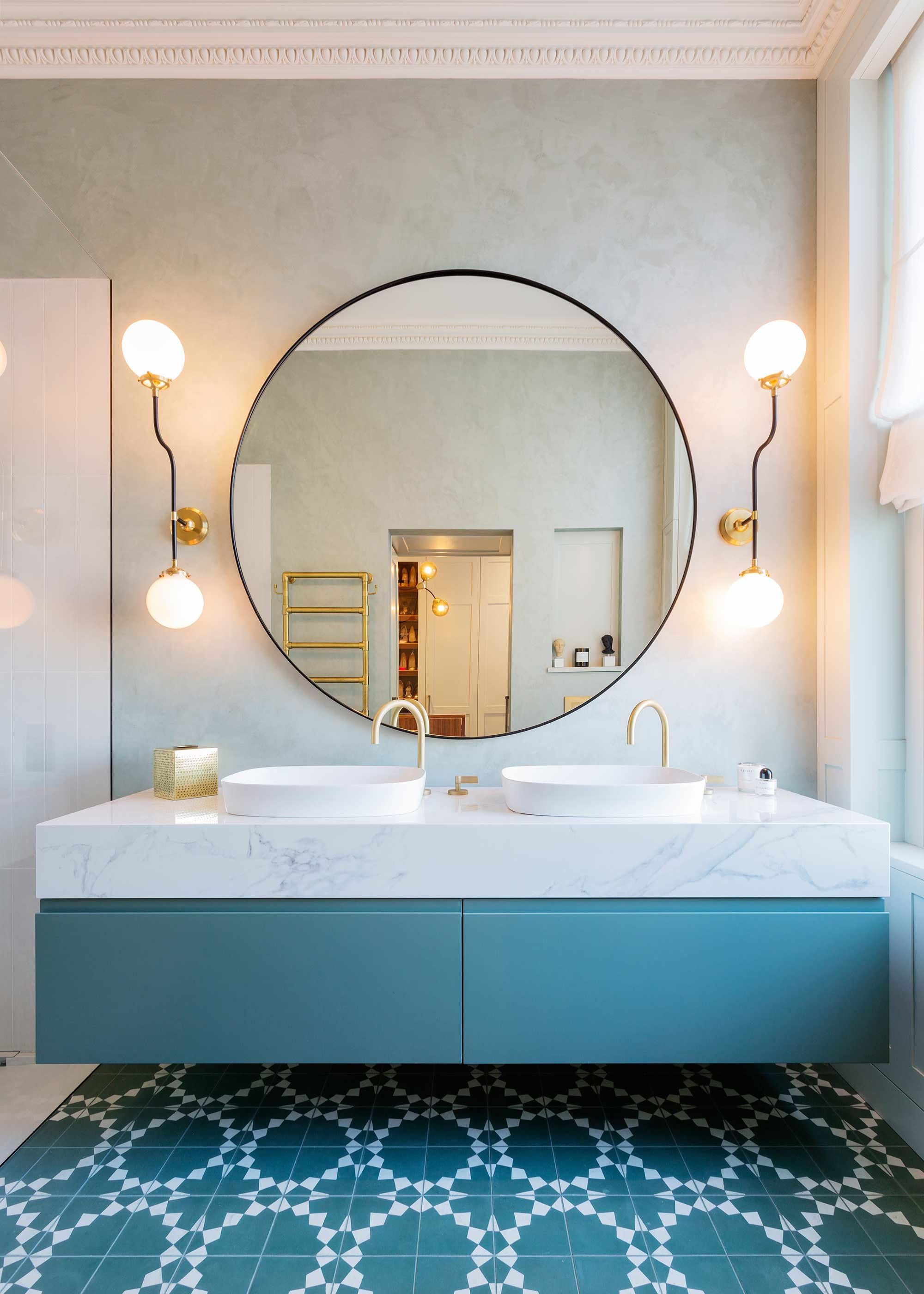 modern blue bathroom with oversized round wall mirror