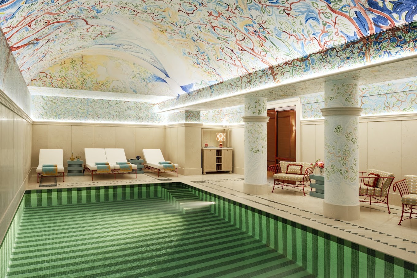 A stunningly and creatively decorated hotel spa features mural-like walls and pillars, and a pool painted in green stripes of different nuances.