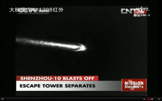 The Long March 2F rocket carrying the Shenzhou 10 mission ejects its emergency escape tower during launch.